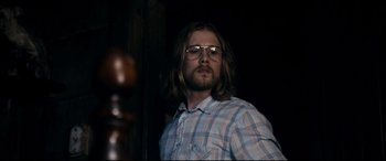 Movie still from “Evil Dead” (2013), directed by Fede Alvarez – A man with long hair wearing glasses and a plaid shirt; Medium shot, Low angle