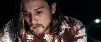Movie still from “Evil Dead” (2013), directed by Fede Alvarez – A person with long hair and a beard; Close Up shot, High angle