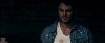 Movie still from “Evil Dead” (2013), directed by Fede Alvarez – A person wearing a jean jacket; Close Up shot, Over the shoulder angle