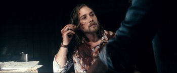 Movie still from “Evil Dead” (2013), directed by Fede Alvarez – A man with a beard and a messy hair style; Close Up shot, Over the shoulder angle