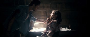 Movie still from “Evil Dead” (2013), directed by Fede Alvarez – A man touching the face of a woman in a dark room; Medium shot, Over the shoulder angle