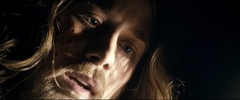 Movie still from “Evil Dead” (2013), directed by Fede Alvarez – A person with long hair and a beard; Extreme Close Up shot, Low angle