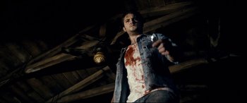 Movie still from “Evil Dead” (2013), directed by Fede Alvarez – A man holding a beer in his hand and looking up; Medium shot, Low angle