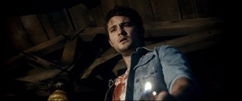 Movie still from “Evil Dead” (2013), directed by Fede Alvarez – A young man holding a flashlight in a barn; Close Up shot, Low angle