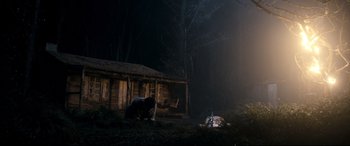 Movie still from “Evil Dead” (2013), directed by Fede Alvarez – A man standing in front of a cabin in the woods; Wide shot, Low angle