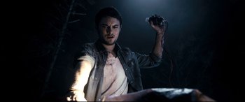 Movie still from “Evil Dead” (2013), directed by Fede Alvarez – A man holding a remote control in his hand; Medium shot, Low angle