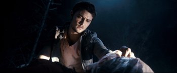 Movie still from “Evil Dead” (2013), directed by Fede Alvarez – A young man is looking at something in the dark; Close Up shot, Over the shoulder angle