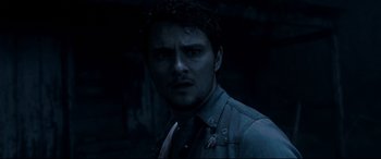 Movie still from “Evil Dead” (2013), directed by Fede Alvarez – A person wearing a suit and tie; Close Up shot, Over the shoulder angle