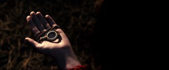 Movie still from “Evil Dead” (2013), directed by Fede Alvarez – A hand holding a small round object in the palm of a hand; Extreme Close Up shot, Overhead angle