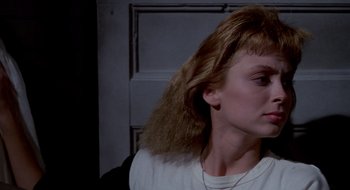 Movie still from “Evil Dead II” (1987), directed by Sam Raimi – A woman with a long blonde hair and a white shirt; Close Up shot, Low angle