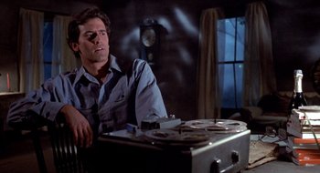 Movie still from “Evil Dead II” (1987), directed by Sam Raimi – A man sitting in front of an old record player; Medium shot, Low angle