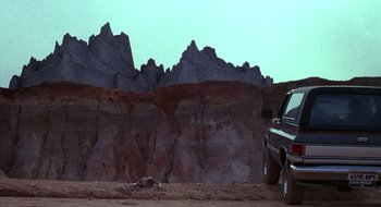 Movie still from “Evil Dead II” (1987), directed by Sam Raimi – A truck parked in front of a mountain range; Extreme Wide shot, Low angle