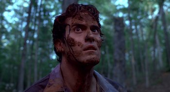 Movie still from “Evil Dead II” (1987), directed by Sam Raimi – A person with mud on his face; Close Up shot, Low angle