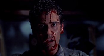 Movie still from “Evil Dead II” (1987), directed by Sam Raimi – A person with blood on his face; Close Up shot, Low angle