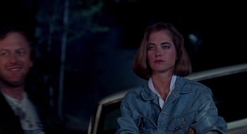 Movie still from “Evil Dead II” (1987), directed by Sam Raimi – A woman sitting in front of a car at night; Close Up shot, Over the shoulder angle