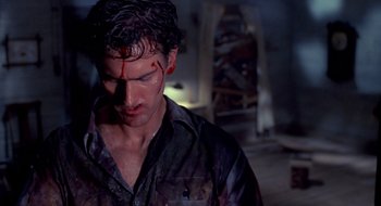 Movie still from “Evil Dead II” (1987), directed by Sam Raimi – A person with blood on his face; Close Up shot, High angle