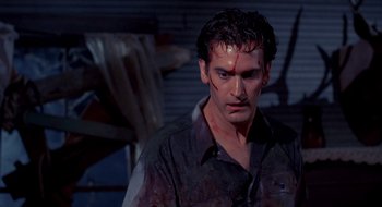Movie still from “Evil Dead II” (1987), directed by Sam Raimi – A person with blood all over his face; Medium shot, Low angle