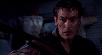 Movie still from “Evil Dead II” (1987), directed by Sam Raimi – A person holding a knife; Close Up shot, Low angle