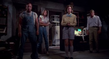 Movie still from “Evil Dead II” (1987), directed by Sam Raimi – A group of people standing in front of a refrigerator; Wide shot, Low angle