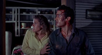 Movie still from “Evil Dead II” (1987), directed by Sam Raimi – A man and a woman with blood on their face; Medium shot, Over the shoulder angle