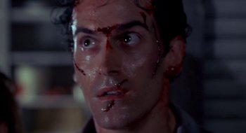 Movie still from “Evil Dead II” (1987), directed by Sam Raimi – A person with blood all over his face; Close Up shot, Low angle