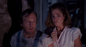 Movie still from “Evil Dead II” (1987), directed by Sam Raimi – A man and a woman standing next to each other in front of a window; Close Up shot, Low angle