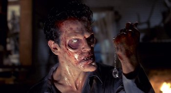 Movie still from “Evil Dead II” (1987), directed by Sam Raimi – A person wearing a zombie makeup; Close Up shot, High angle