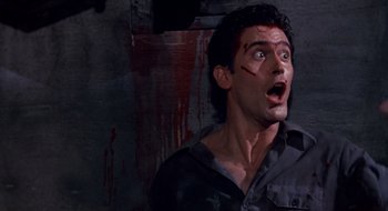 Movie still from “Evil Dead II” (1987), directed by Sam Raimi – A man with blood all over his face and mouth; Close Up shot, Low angle