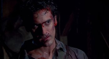 Movie still from “Evil Dead II” (1987), directed by Sam Raimi – A person with blood all over his face; Close Up shot, Over the shoulder angle