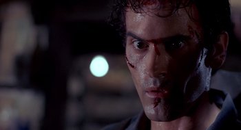 Movie still from “Evil Dead II” (1987), directed by Sam Raimi – A person with blood on his face; Close Up shot, Low angle