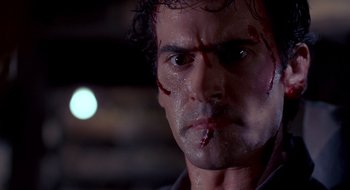 Movie still from “Evil Dead II” (1987), directed by Sam Raimi – A man's face with blood on his face; Close Up shot, Low angle