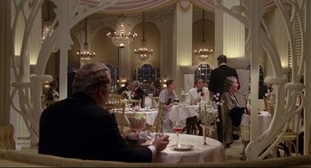 Movie still from “Evil Under the Sun” (1982), directed by Guy Hamilton – A group of people sitting at tables with wine glasses; Wide shot, High angle