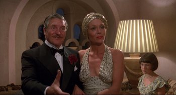 Movie still from “Evil Under the Sun” (1982), directed by Guy Hamilton – An older man and a younger woman posing for a picture; Medium shot, Low angle