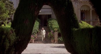 Movie still from “Evil Under the Sun” (1982), directed by Guy Hamilton – A man walking down the steps of a house; Wide shot, Low angle