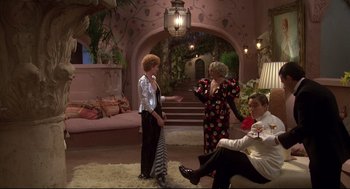 Movie still from “Evil Under the Sun” (1982), directed by Guy Hamilton – A group of people sitting in a living room; Wide shot, High angle