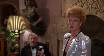 Movie still from “Evil Under the Sun” (1982), directed by Guy Hamilton – An older man and a woman in formal wear; Medium shot, Over the shoulder angle