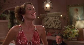 Movie still from “Evil Under the Sun” (1982), directed by Guy Hamilton – A woman in a red dress and a man in a black suit; Medium shot, Low angle