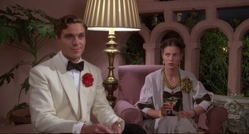 Movie still from “Evil Under the Sun” (1982), directed by Guy Hamilton – A man and a woman sitting next to each other; Medium shot, Low angle