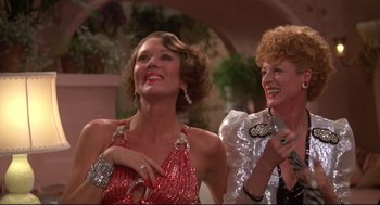 Movie still from “Evil Under the Sun” (1982), directed by Guy Hamilton – Two older women are laughing together at an event; Close Up shot, Low angle