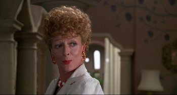 Movie still from “Evil Under the Sun” (1982), directed by Guy Hamilton – A person wearing a suit and tie; Close Up shot, Over the shoulder angle