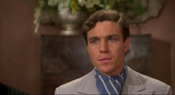 Movie still from “Evil Under the Sun” (1982), directed by Guy Hamilton – A person wearing a suit and tie; Close Up shot, Over the shoulder angle