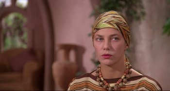Movie still from “Evil Under the Sun” (1982), directed by Guy Hamilton – A woman wearing a head scarf and a necklace; Close Up shot, Low angle