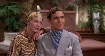 Movie still from “Evil Under the Sun” (1982), directed by Guy Hamilton – A man and a woman sitting next to each other; Medium shot, Low angle