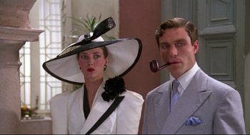 Movie still from “Evil Under the Sun” (1982), directed by Guy Hamilton – A man and a woman wearing hats with a pipe in their mouth; Close Up shot, Low angle