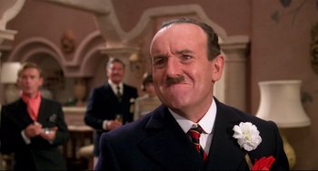 Movie still from “Evil Under the Sun” (1982), directed by Guy Hamilton – An older man with a mustache and a suit and tie; Close Up shot, Low angle