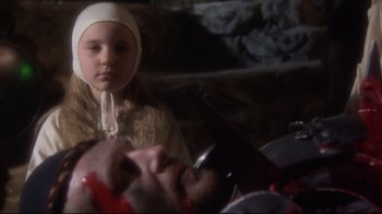 Movie still from “Excalibur” (1981), directed by John Boorman – A young girl wearing a white hat looking at the camera; Close Up shot, High angle