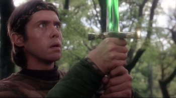 Movie still from “Excalibur” (1981), directed by John Boorman – A person holding a sword; Close Up shot, Low angle