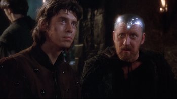Movie still from “Excalibur” (1981), directed by John Boorman – Two men are standing next to each other; Close Up shot, Over the shoulder angle
