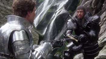 Movie still from “Excalibur” (1981), directed by John Boorman – Two men dressed in medieval armor near a waterfall; Medium shot, Low angle