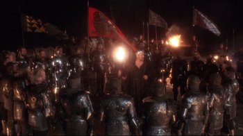 Movie still from “Excalibur” (1981), directed by John Boorman – A group of men in armor standing next to each other; Wide shot, High angle